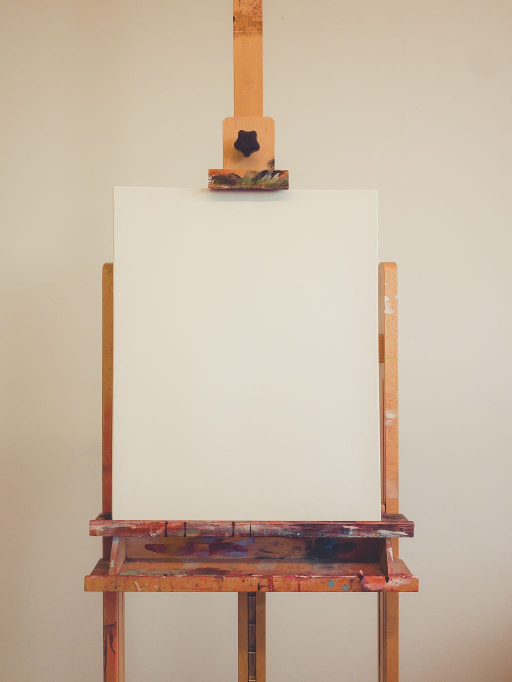 A blank canvas on a wooden artist’s easel.