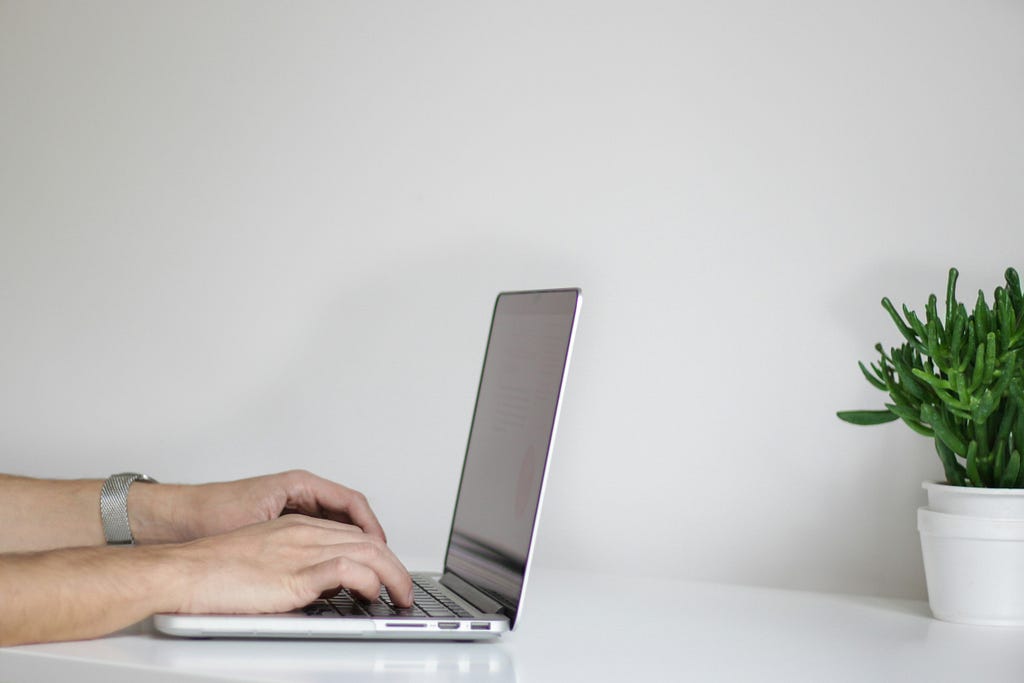 Hands typing on a computer