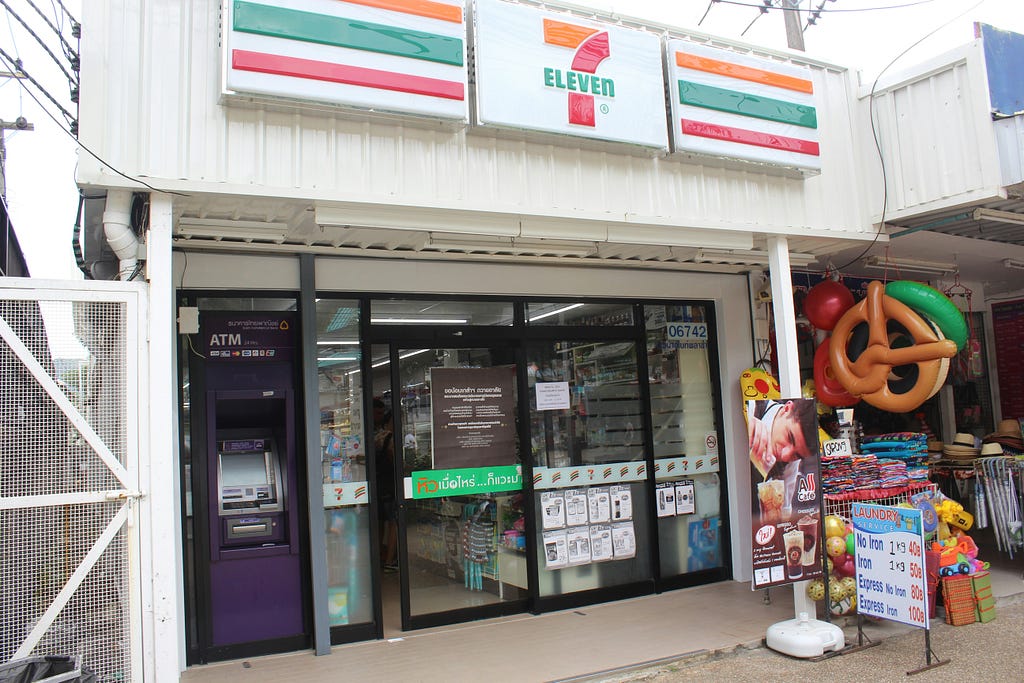 front of a 7-eleven convenience store with an ATM built into the wall