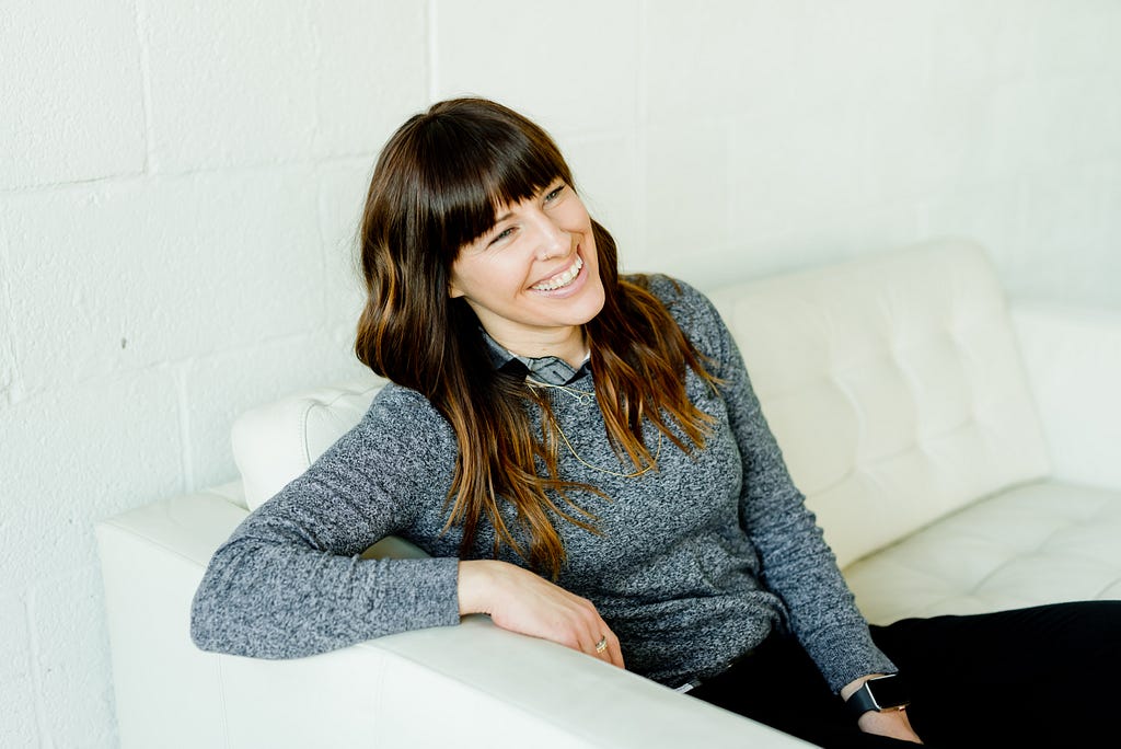 A woman sitting on a couch and smiling.