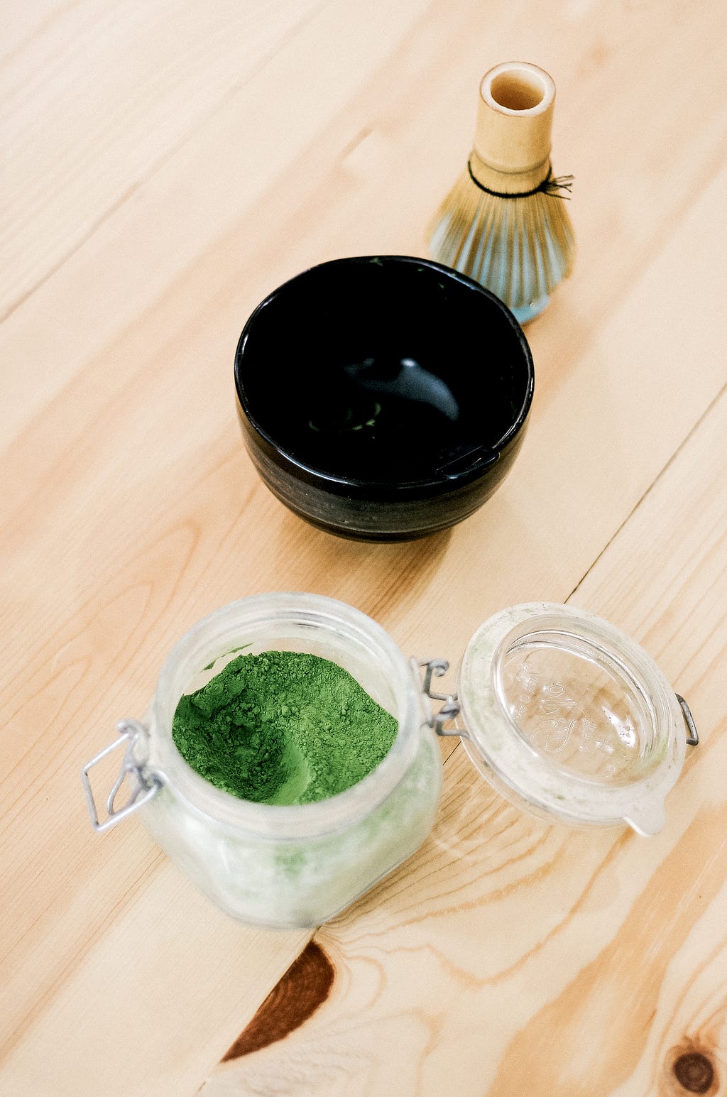 Green Powder in Mason Jar next to empty jar and brush