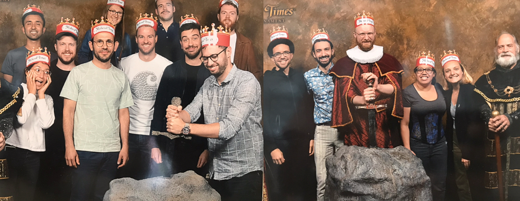 Dilip’s team wearing paper crowns at Medieval Times posing with cast members