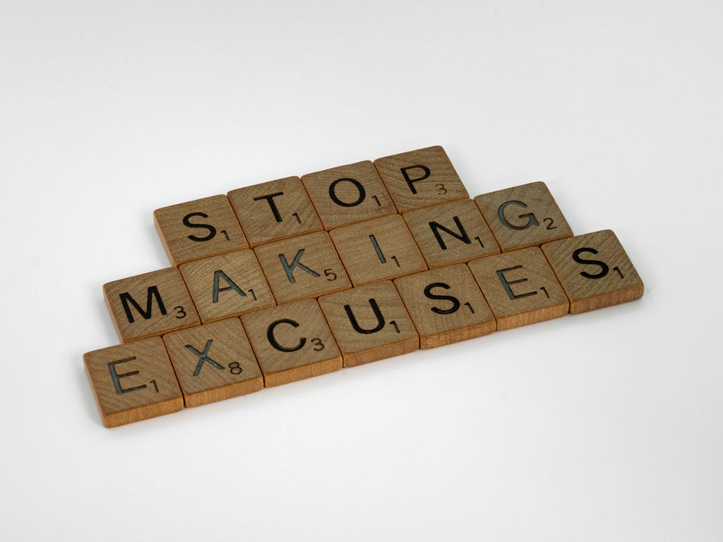 A set of wooden blocks with the word “stop making excuses”
