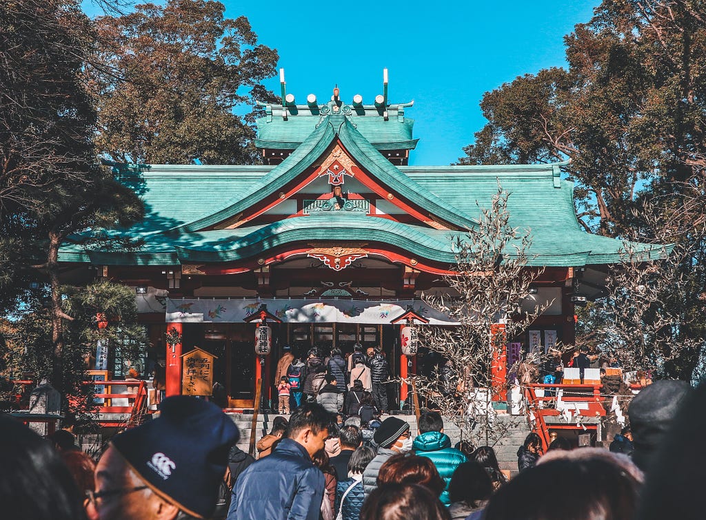 Japanese people visiting a Shinto shrine.