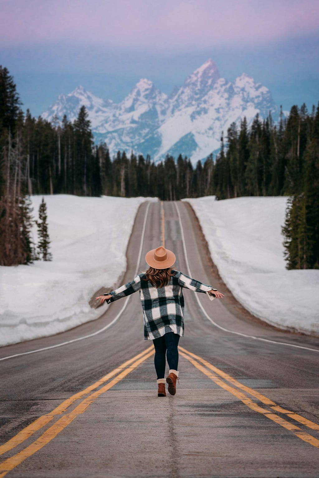 A person walking on the road with snow around them