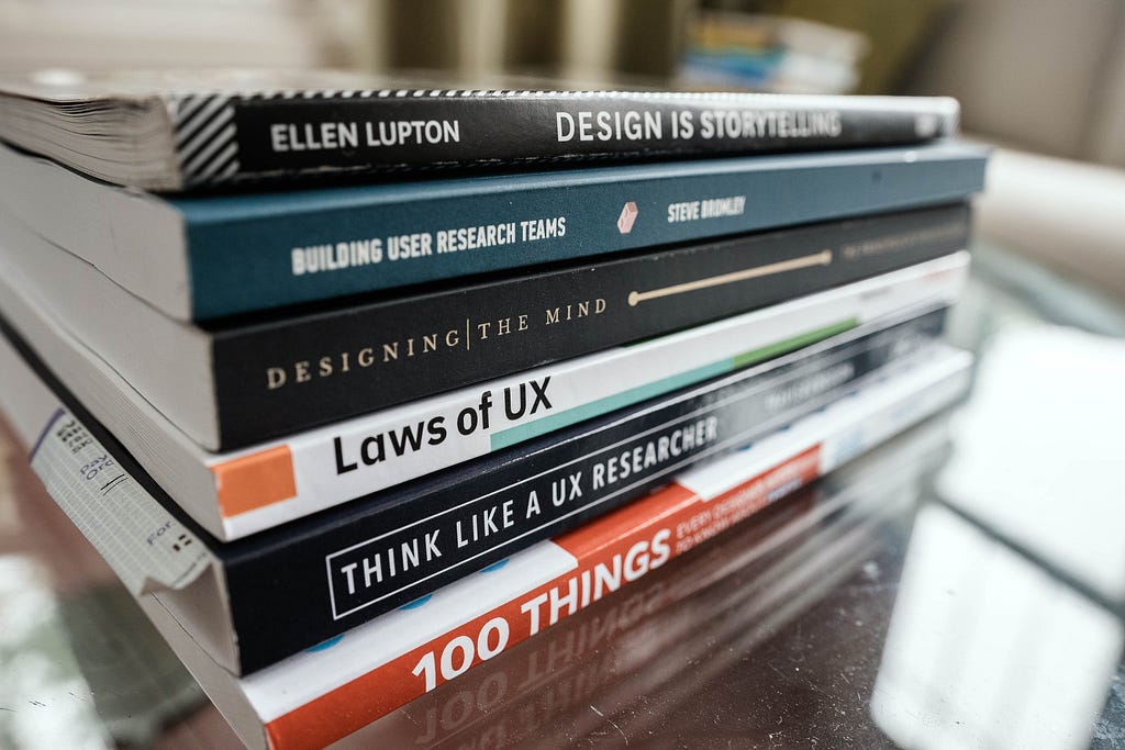 Collection of UX books on a wooden desk.