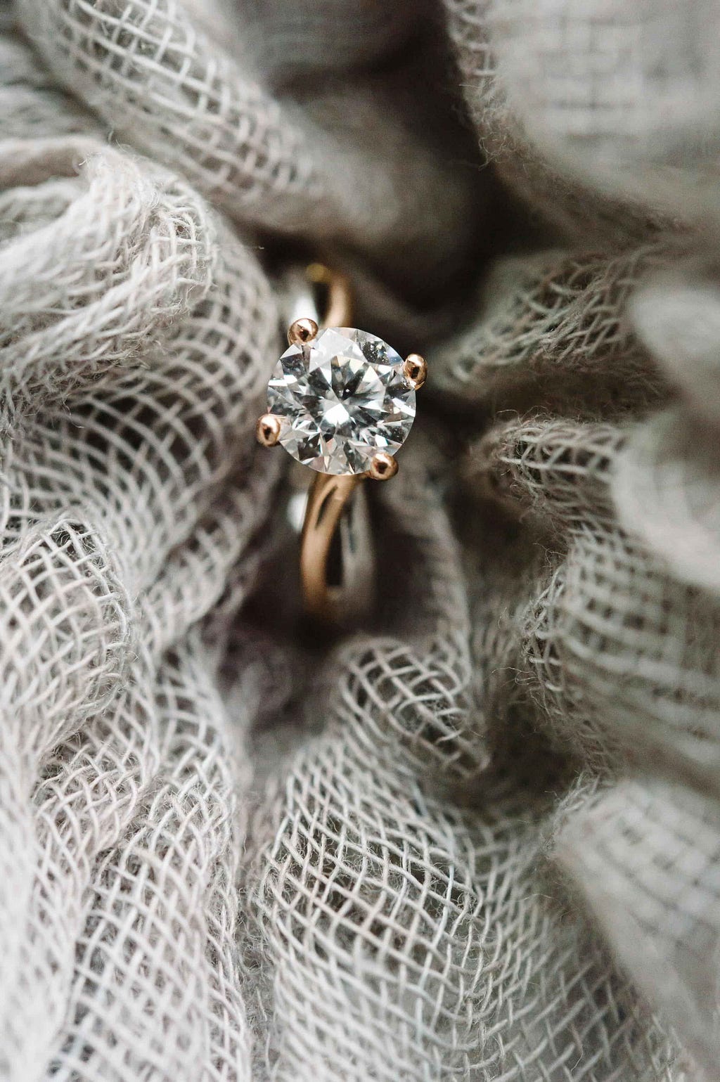 A diamond engagement ring nestled in fabric