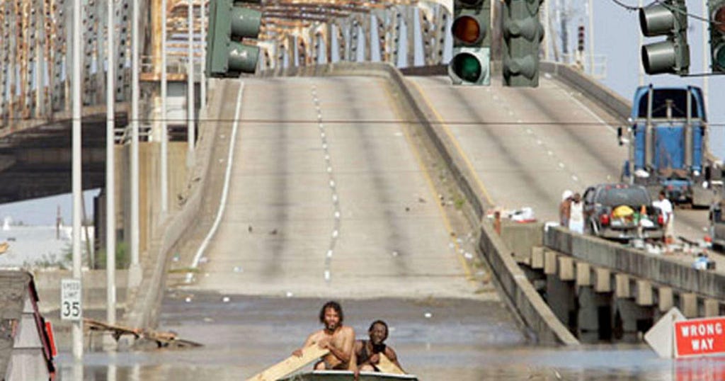 Two residents of New Orleans row a makeshift boat along a flooded highway in the aftermath of Hurricane Katrina.