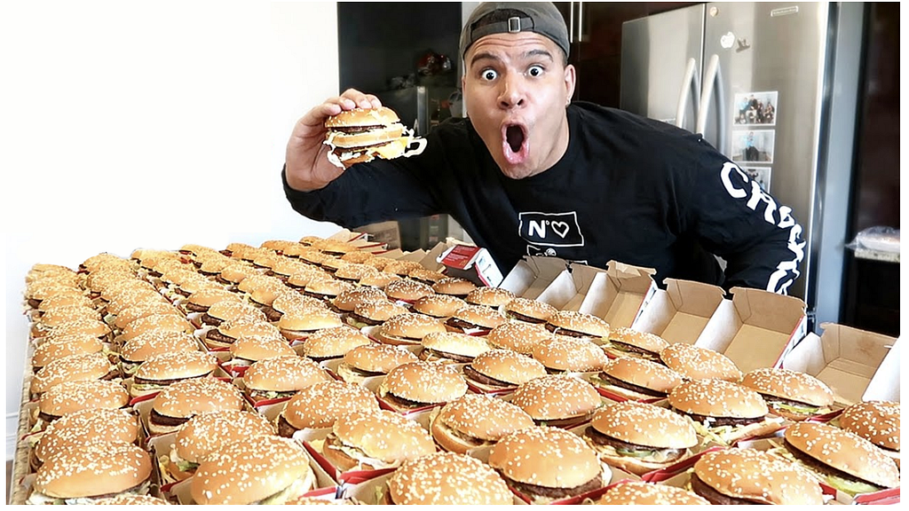 a guy in front of tones of burgers