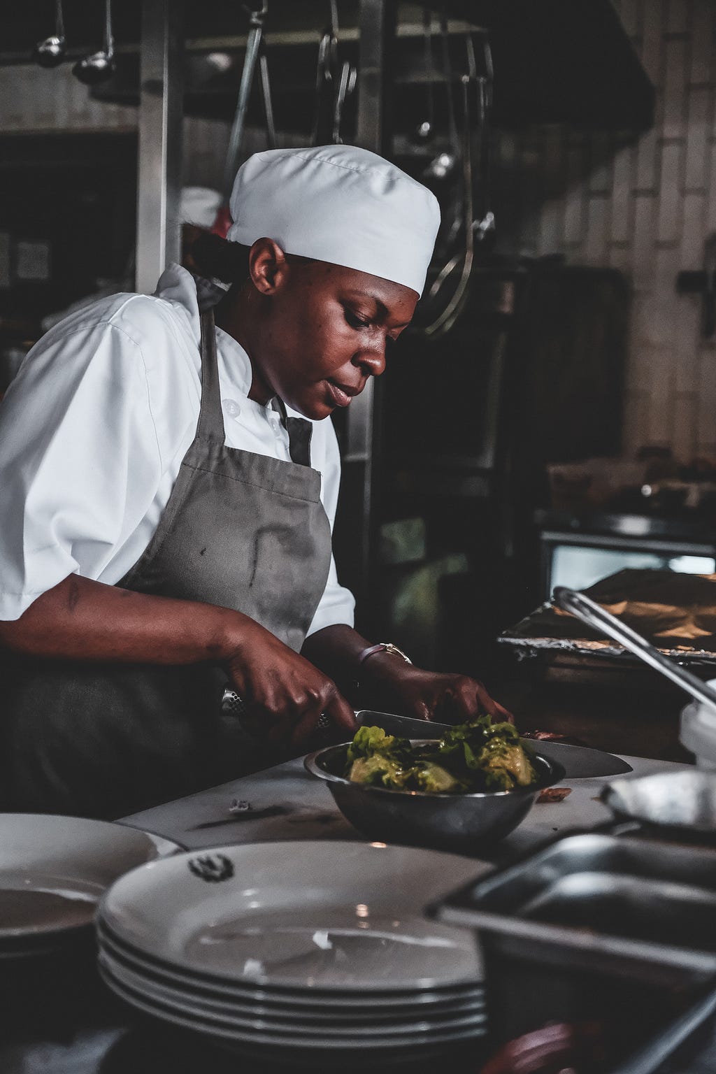 An African American woman working her craft in the kitchen.