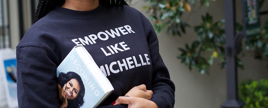 A woman holding a Michelle Obama book