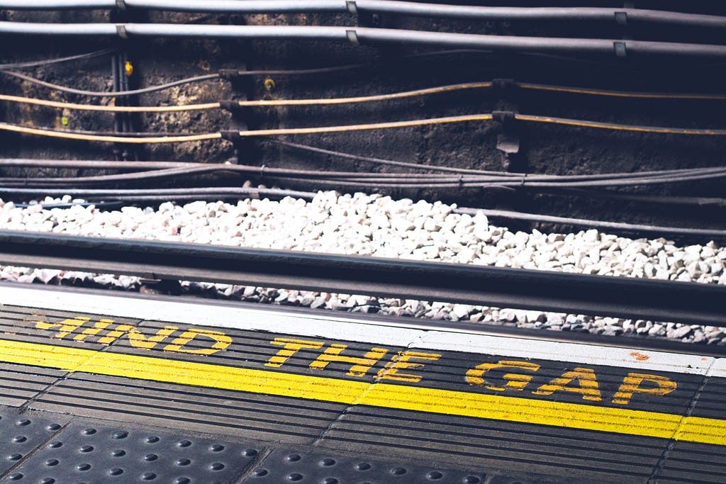 A train platform with the signage “Mind the Gap”