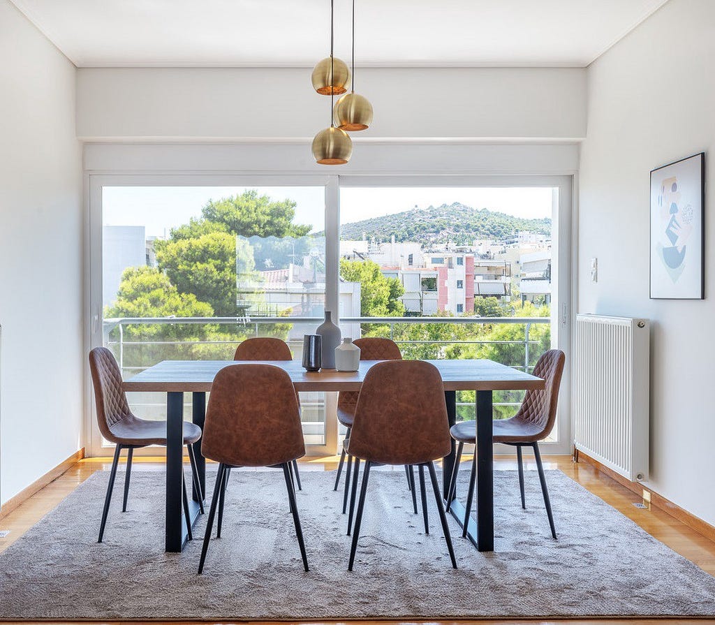 A Blueground apartment dining room in Agia Paraskevi, Athens with a view of the hills