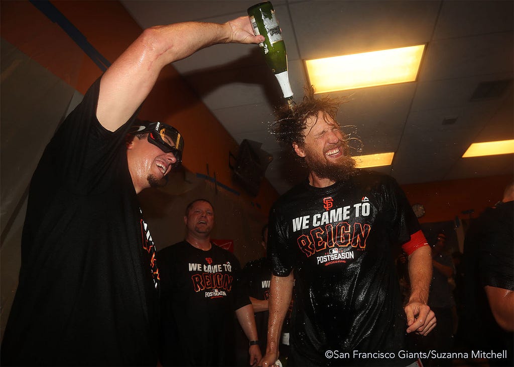 Derek Law and Hunter Pence celebrate in the clubhouse.