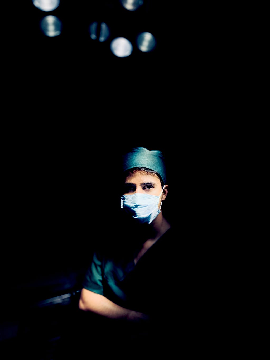 A doctor in scrubs waiting for a patient to operate on