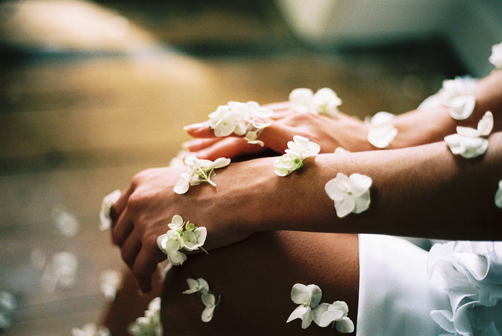 photo of two hands covered in white flower blossoms