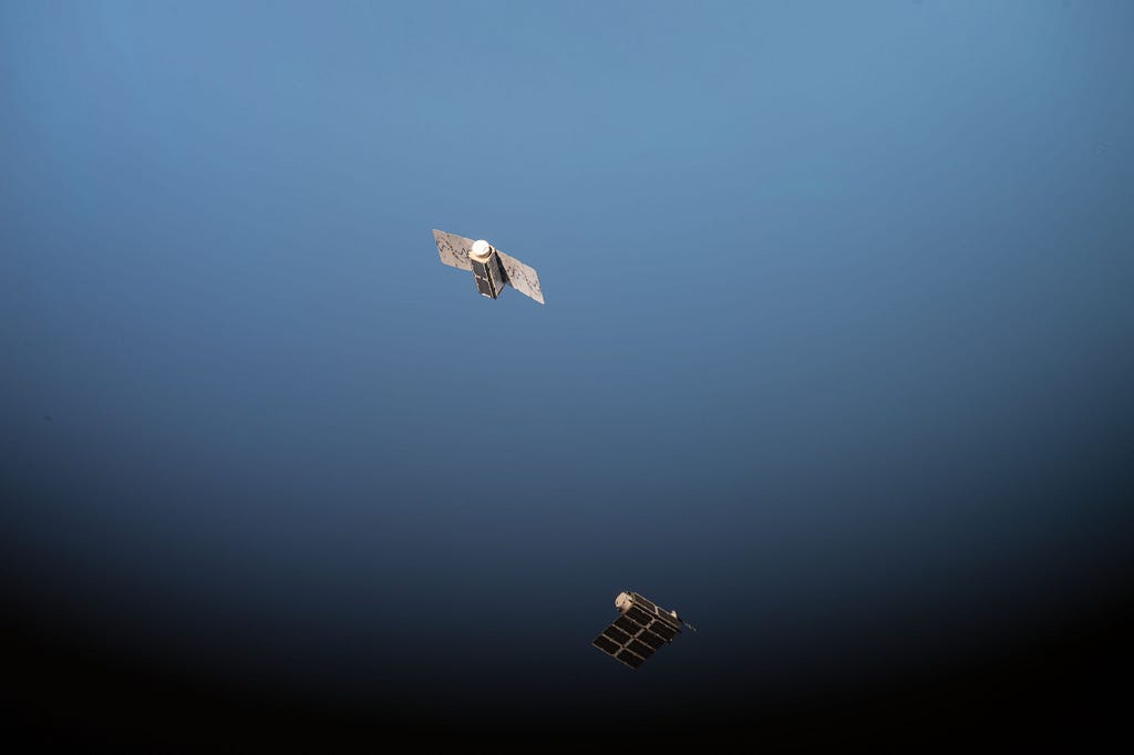 A pair of Doves flying into orbit high above the Earth