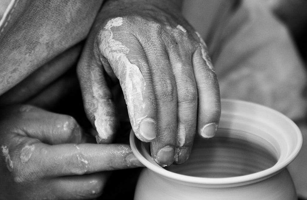Person getting hands dirty while doing pottery