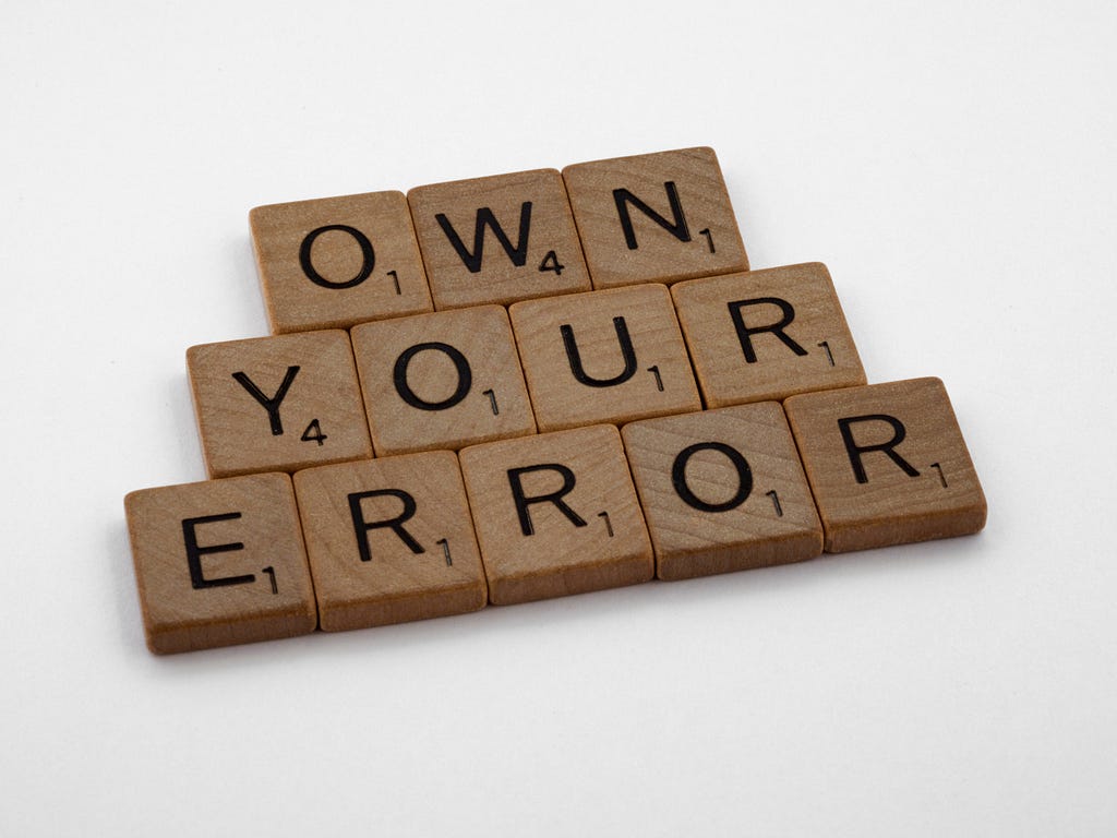Scrabble tiles reading “own your error”