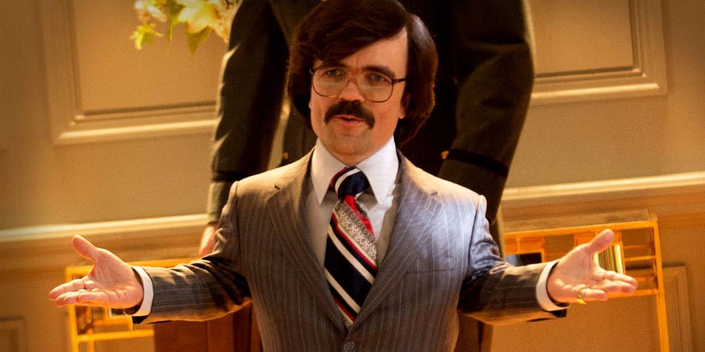 Bolivar Trask has dwarfism, and is walking into the room with his arms outstreached showing all the confidence of a supervillian.