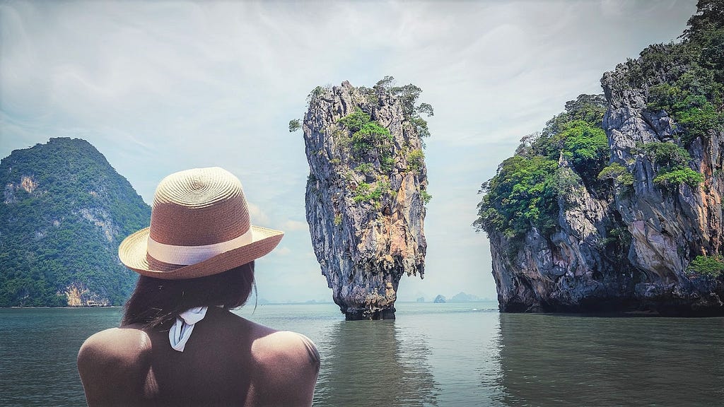 A woman looking at a karst tower rock.