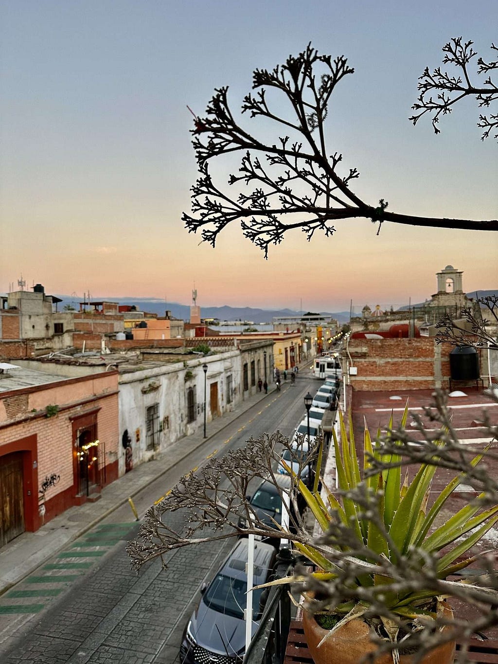 A view from a rooftop bar in Oaxaca overlooking the city with the sun setting
