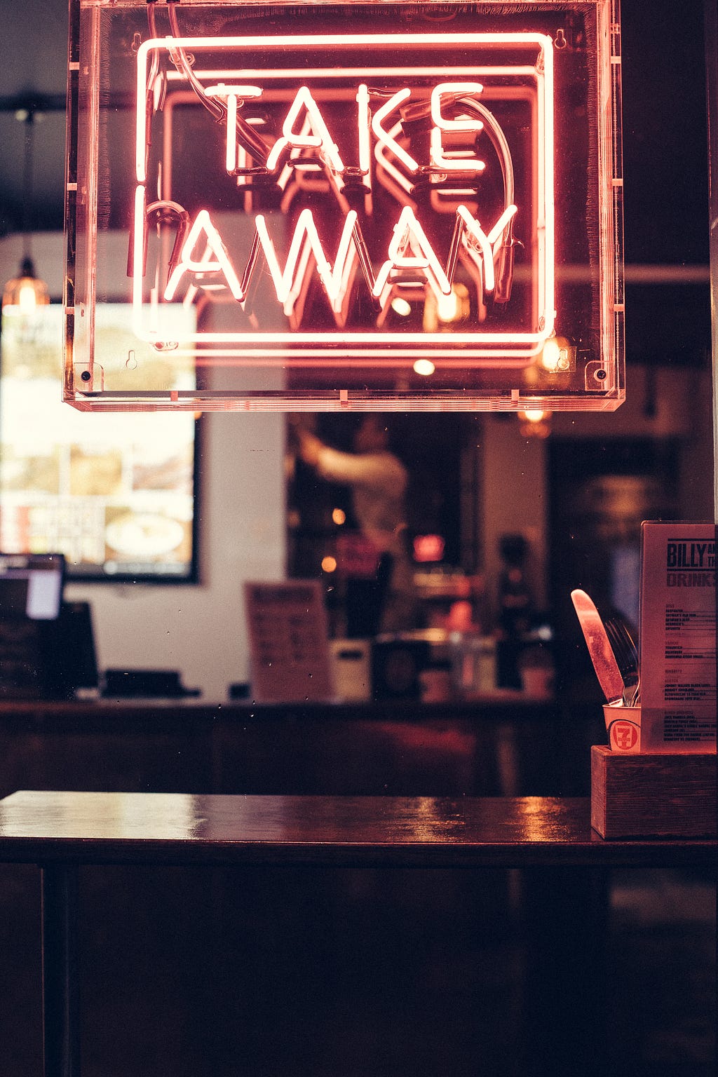 A neon Take Away sign in a restaurant