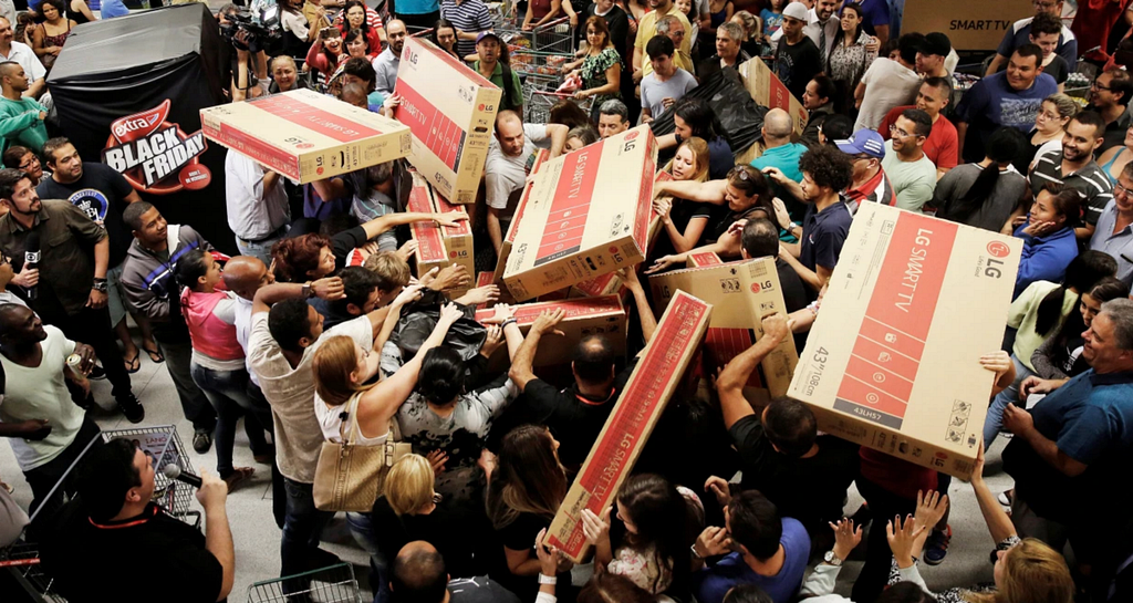 Crowds of people reaching for the same boxes and items during Black Friday.