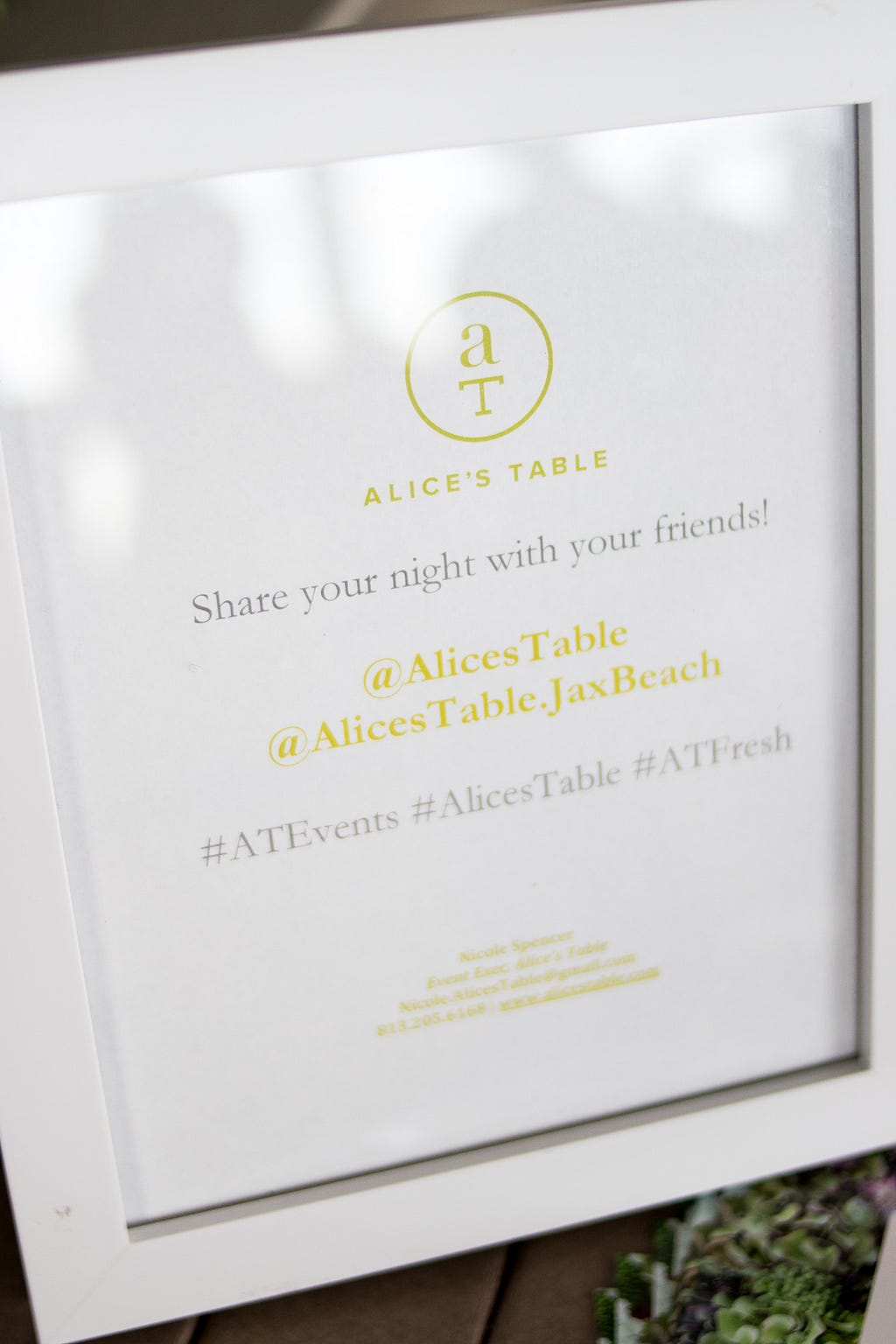 Sign with text: Alice's Table - Share your night with your friends! @AlicesTable @AlicesTable.JaxBeach #ATEvents #AlicesTable #ATFresh