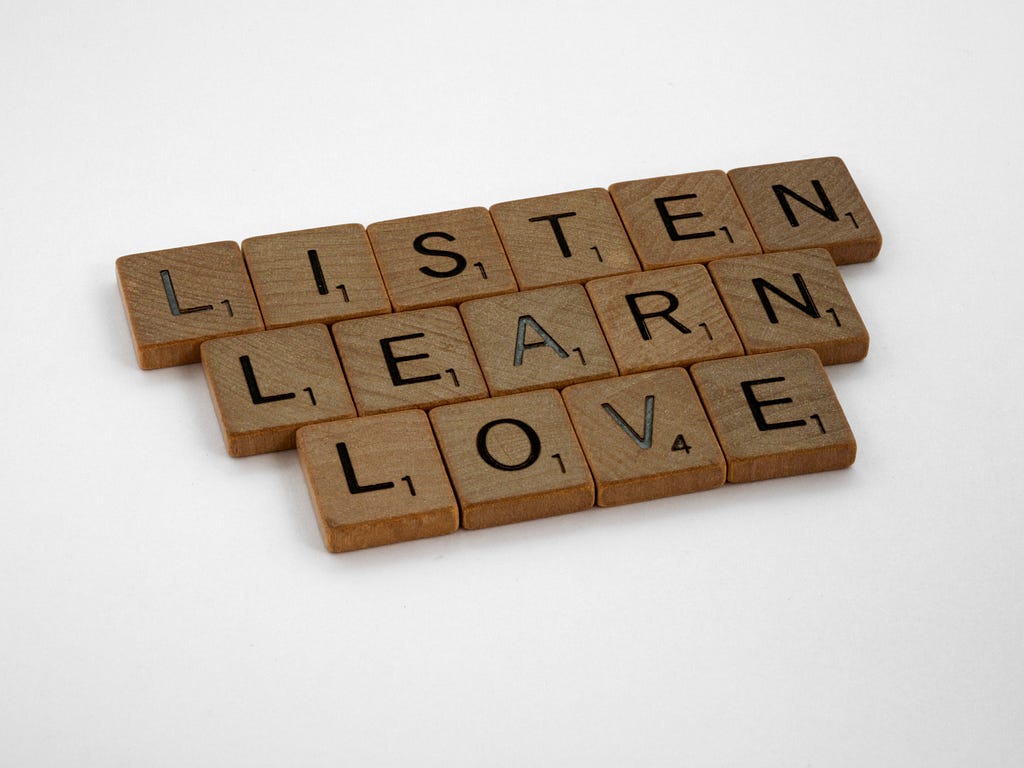 Scrabble tiles spelling ‘listen’, ‘learn’, ‘love’
