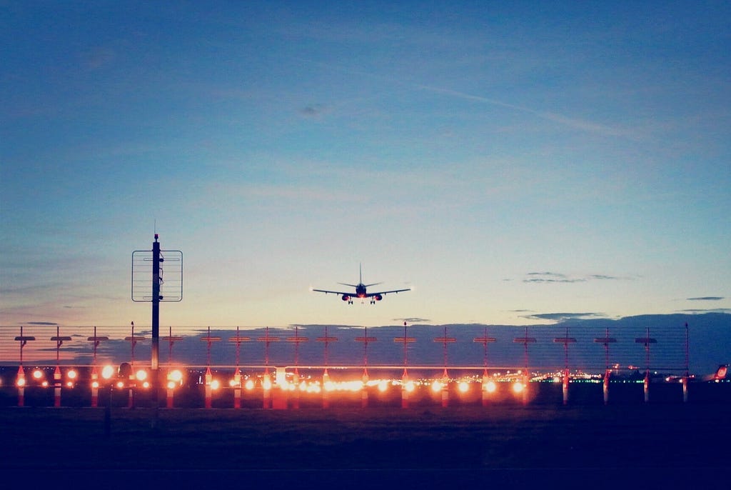 Image of a aircraft landing on a runway during twilight!