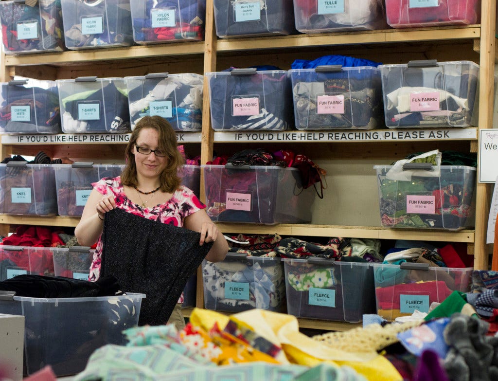 Sara West, a Northwest Workforce intern, folds and sorts fabric in the Ragfinery. West decided that Ragfinery would be a fun and creative place to intern. Bailey Barnard / Klipsun Magazine