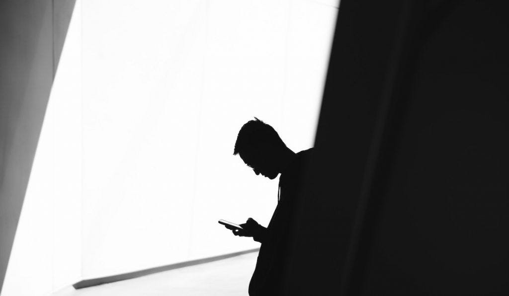 sillouette of person looking at their phone