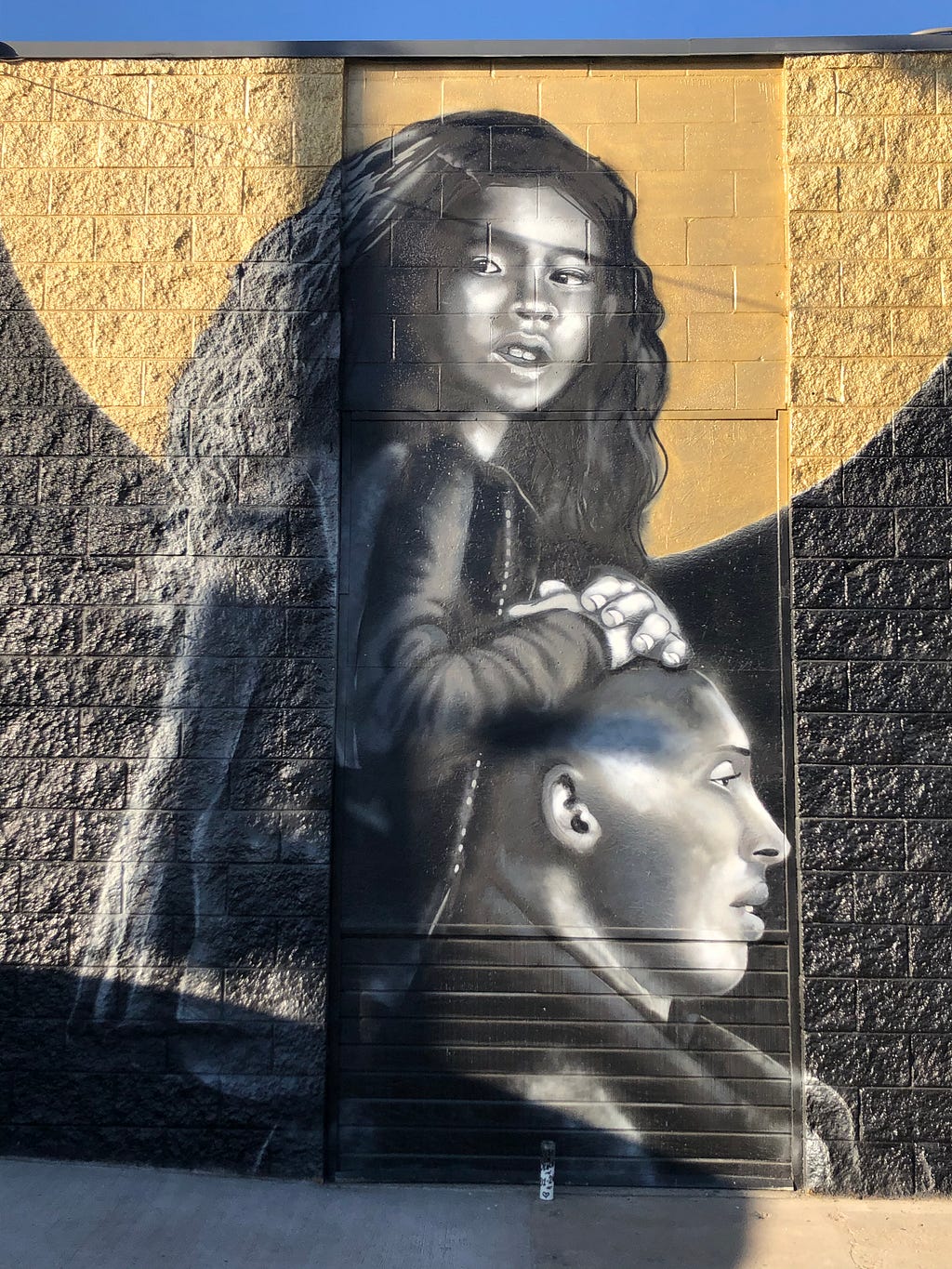 Street art tribute mural of Gianna Bryant riding on Kobe Bryant’s shoulders