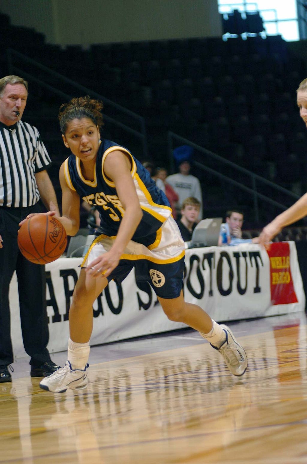 Diana Lopez dribbles a basketball during an RMAC game