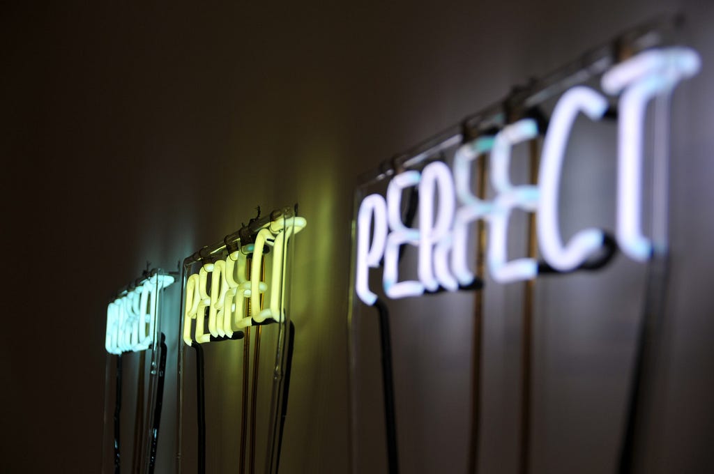 letter lights spelling PERFECT three times in a row on a wall // Photographer: Jonathan Hoxmark | Source: Unsplash