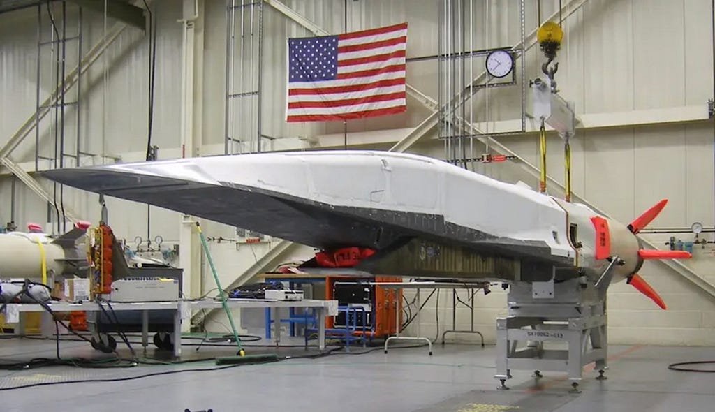 A warehouse containing a hypersonic cruise missile and an American flag in the background