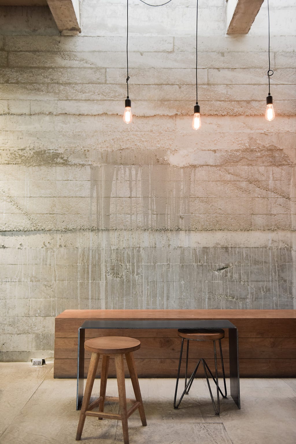 A wooden desk with two empty stools next to it