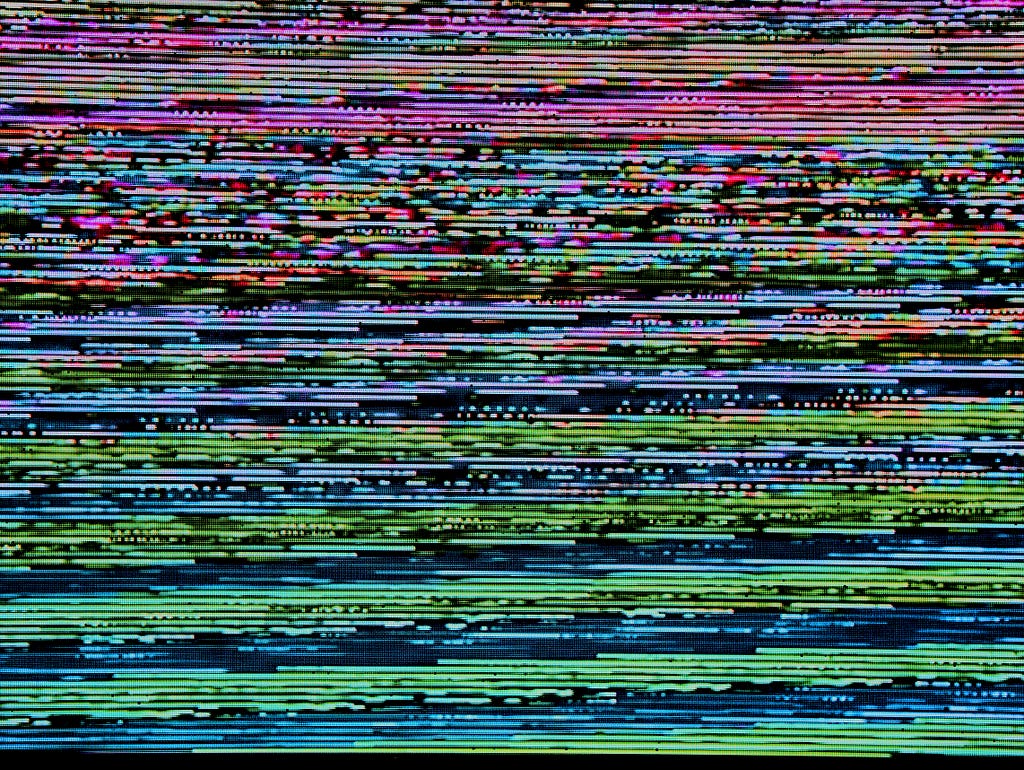Image of glitch screen, giving the feeling of technology not working or disconnection. By Michael Dziedzic on Unsplash.