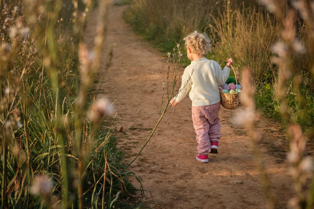 Young Girl with a basket walking on a path searching for Easter Eggs