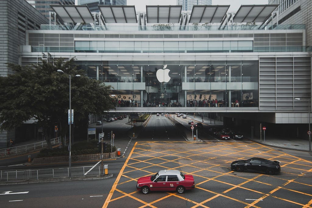 Prédio da apple com uma rua na frente e um carro vermelho se destacando. — distribuição privada apple app store
