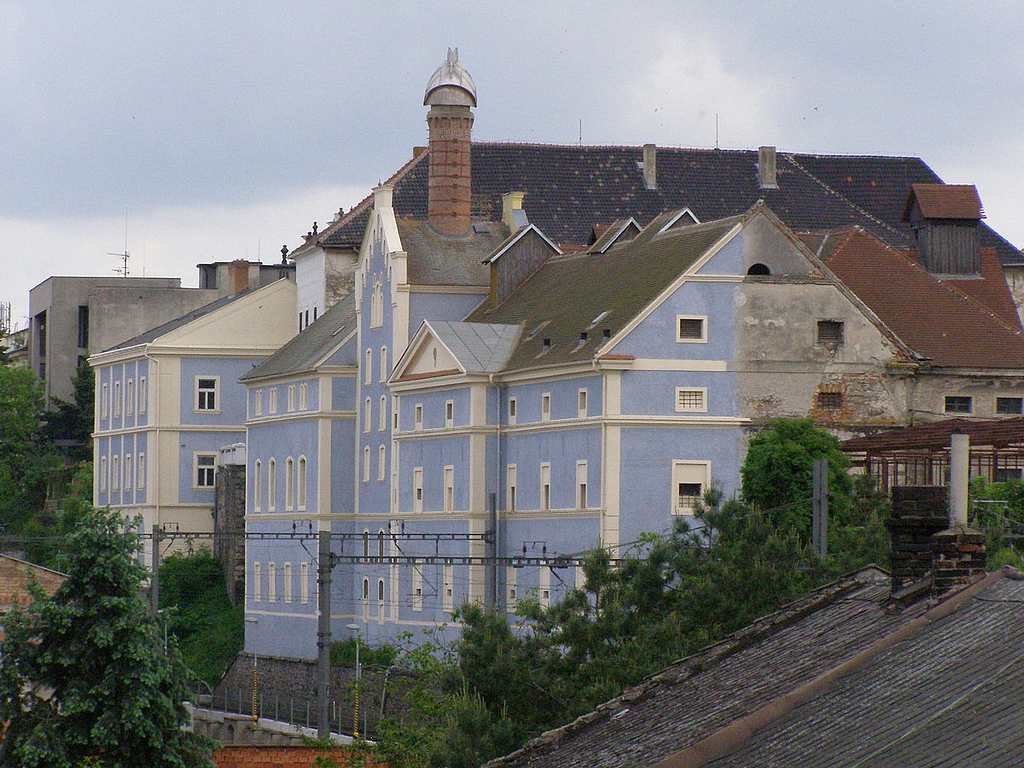 A house with the facade painted in beautiful baby blue and white, and the back unpainted nasty cement
