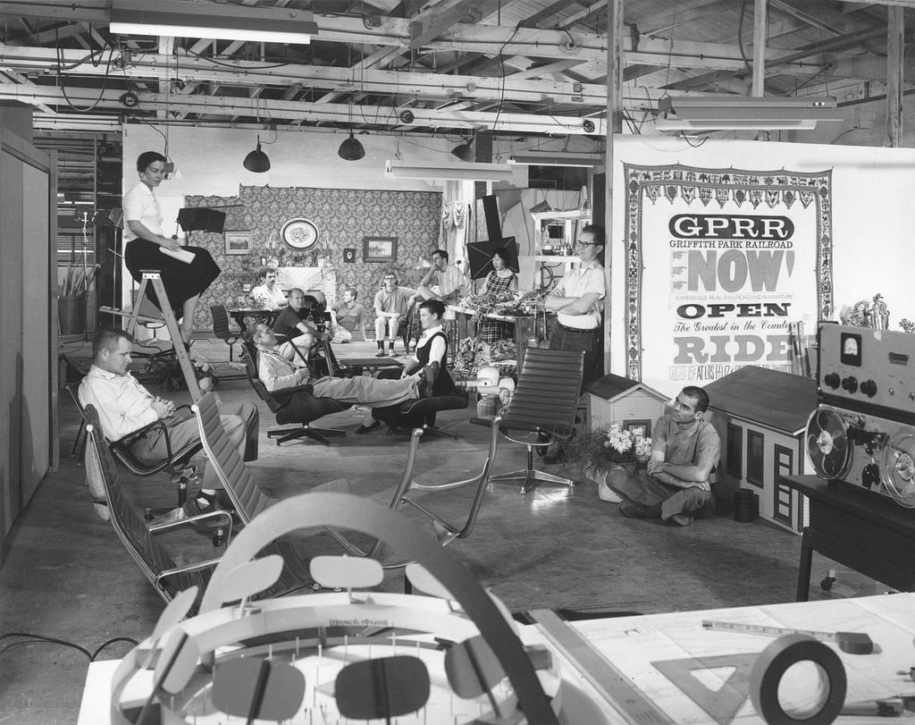 Four productive, colorful decades of design work existed inside the Eames Office in Venice, California. Charles and Ray share the Eames Lounge Chair and Ottoman while surrounded by their staff. Photograph taken for Vogue magazine, August 1959. © Eames Office, LLC. All rights reserved (Image source: Metmuseum)