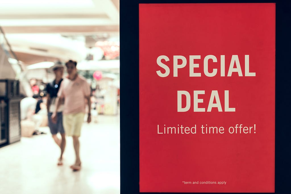 A couple is walking in a mall near a sign that says “Special Deal, Limited Time Offer!”