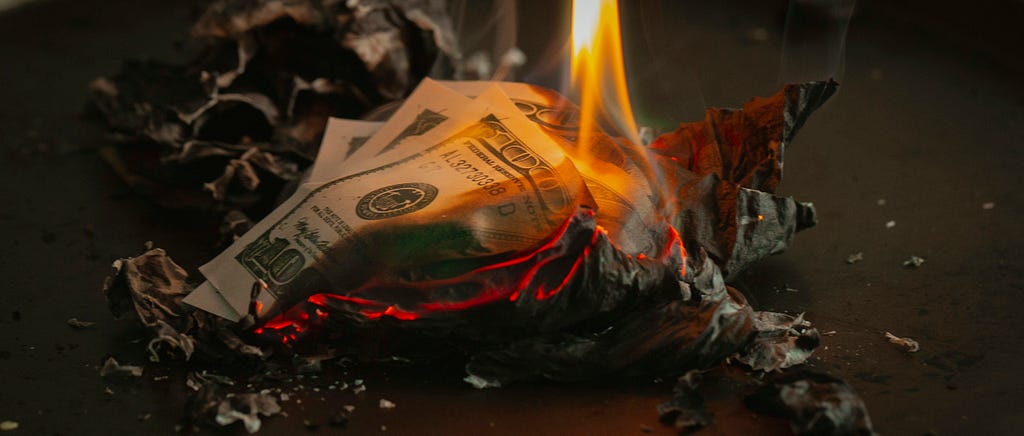 A burnt pile of bills on fire.