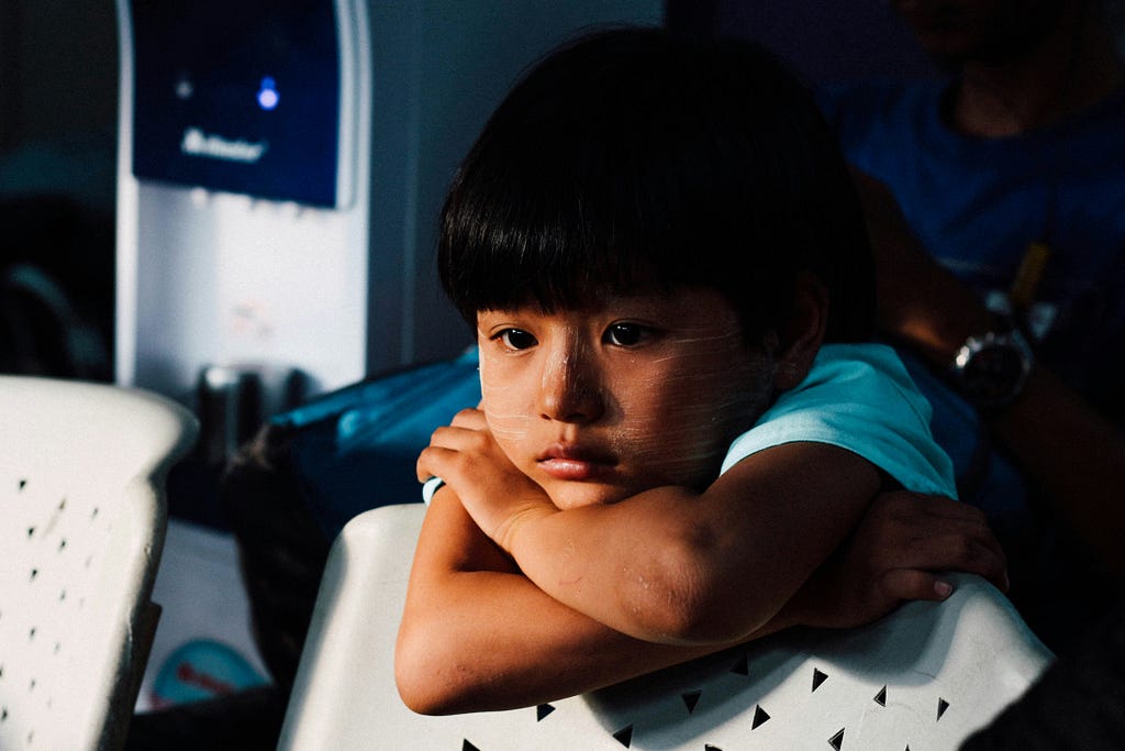 A small autistic child sitting alone and thinking something