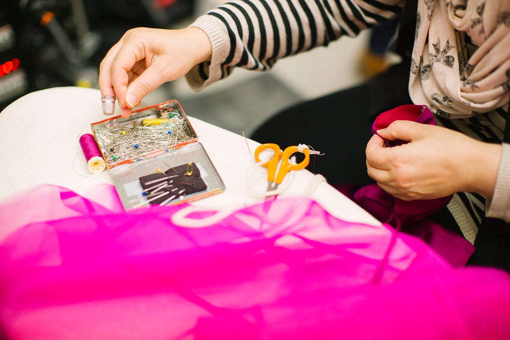 A person pinning fabric to sew together.