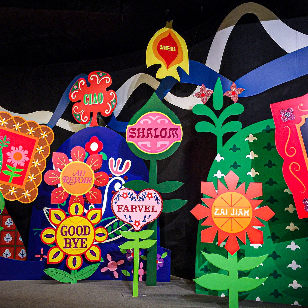 Painted flowers with various languages saying “goodbye”
