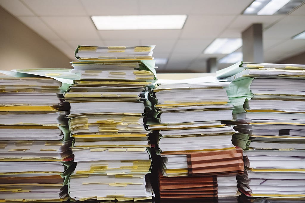 Stacks of paper and file folders on a table