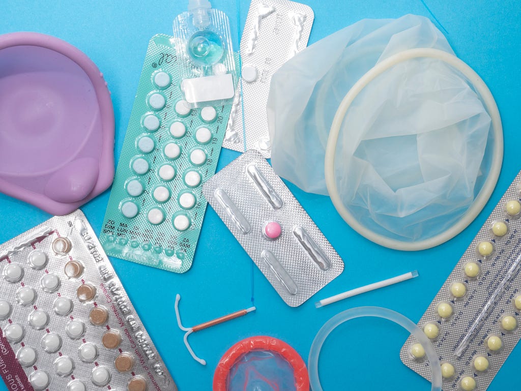Various contraceptive devices against a blue background.